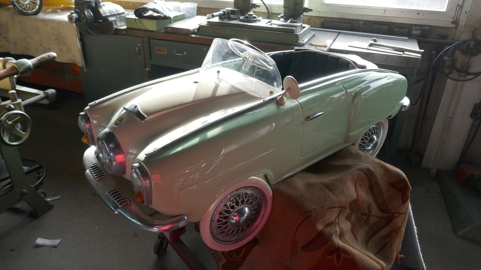 Ein Spielzeugauto steht auf einem Tisch in einer Garage.